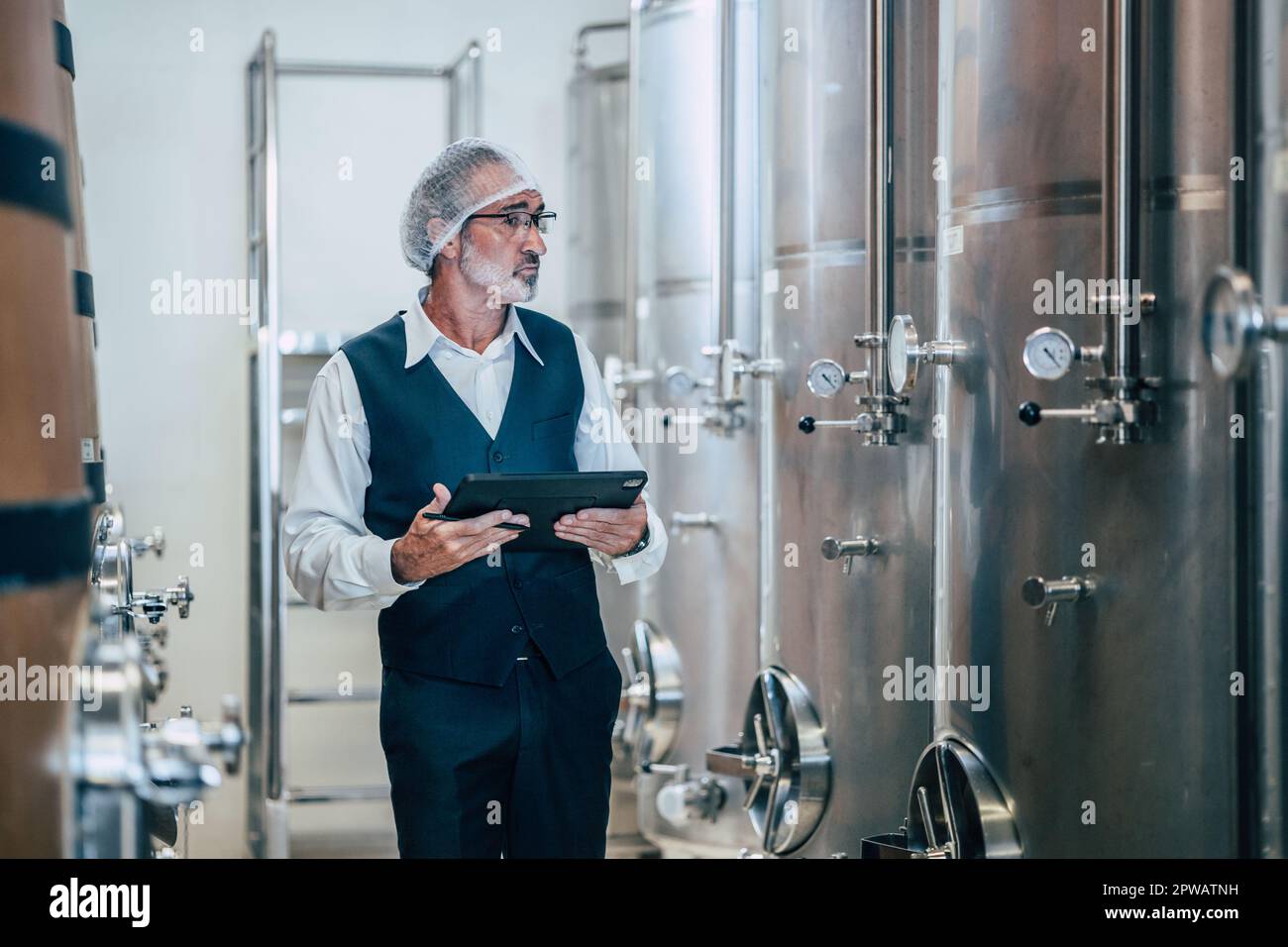 Viticulteur travaillant dans une grande usine moderne de vins alcool industrie de boisson qualité et contrôle de fermentation Banque D'Images