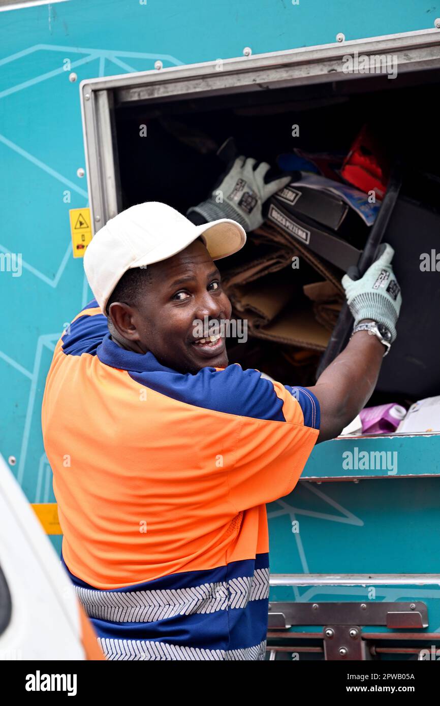 Un ouvrier du conseil vidant la boîte de recyclage des déchets triés par ménage dans un camion de recyclage Banque D'Images