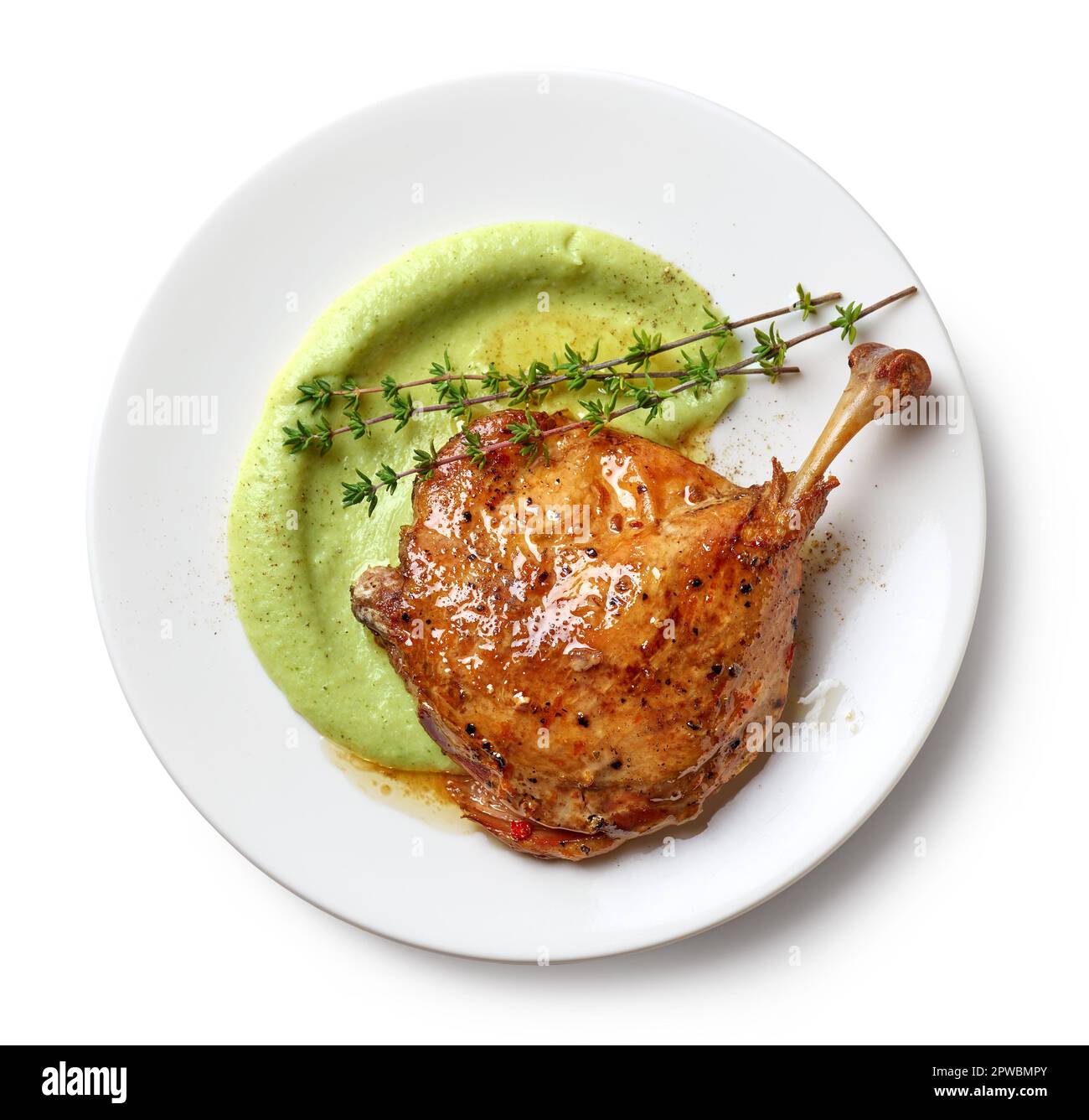 assiette de confit de jambe de canard et purée de brocoli isolée sur fond blanc, vue du dessus Banque D'Images