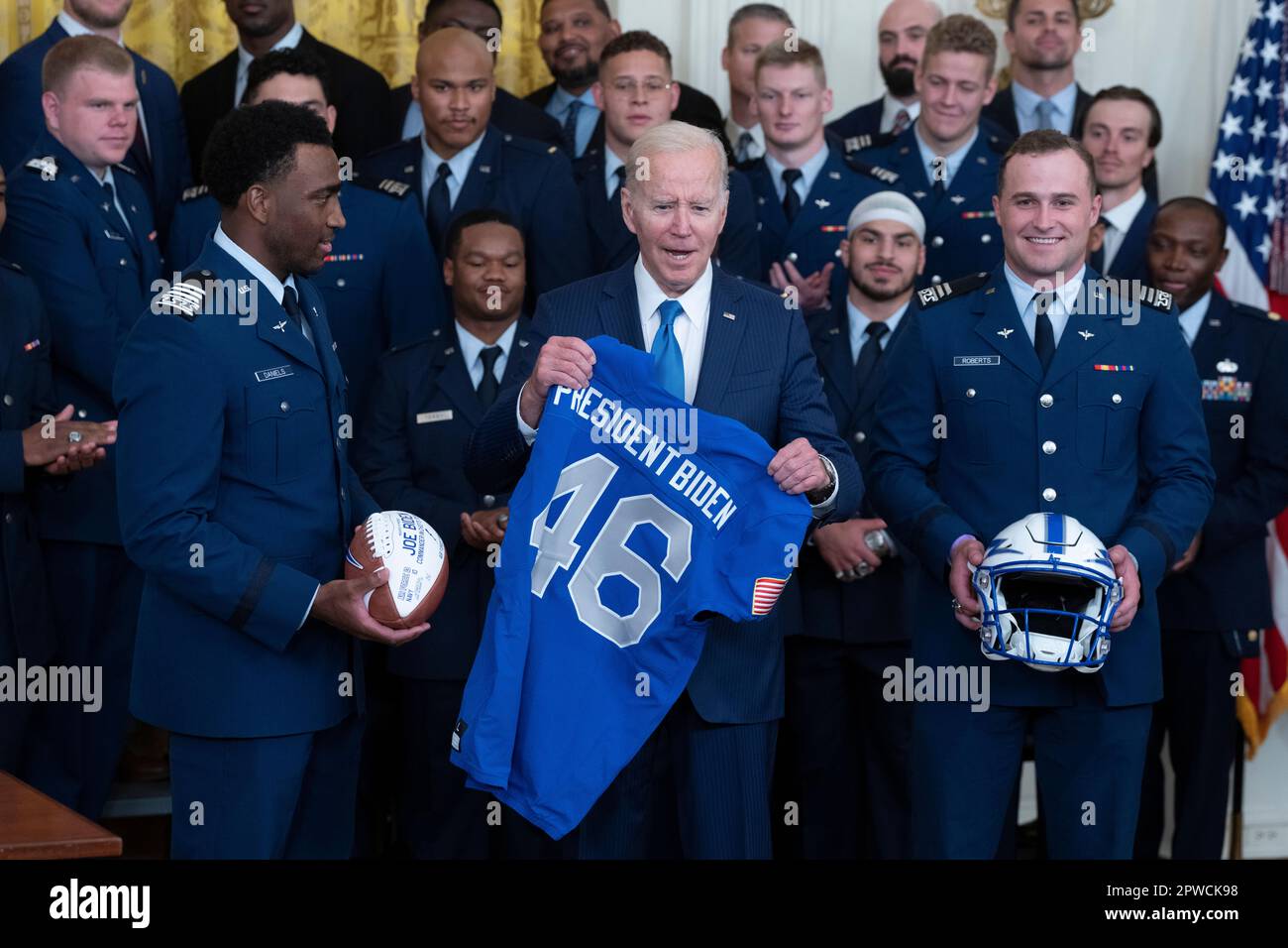 Washington, Vereinigte Staaten. 28th avril 2023. Le président des États-Unis Joe Biden reçoit un ballon de football et un maillot du membre du faucon de la Force aérienne, Haaziq Daniels, et un casque de Brad Roberts lors de la remise du trophée Commandant en Chiefs aux Faucons de la Force aérienne à la Maison Blanche à Washington, DC, 28 avril 2023. Credit: Chris Kleponis/CNP/dpa/Alay Live News Banque D'Images