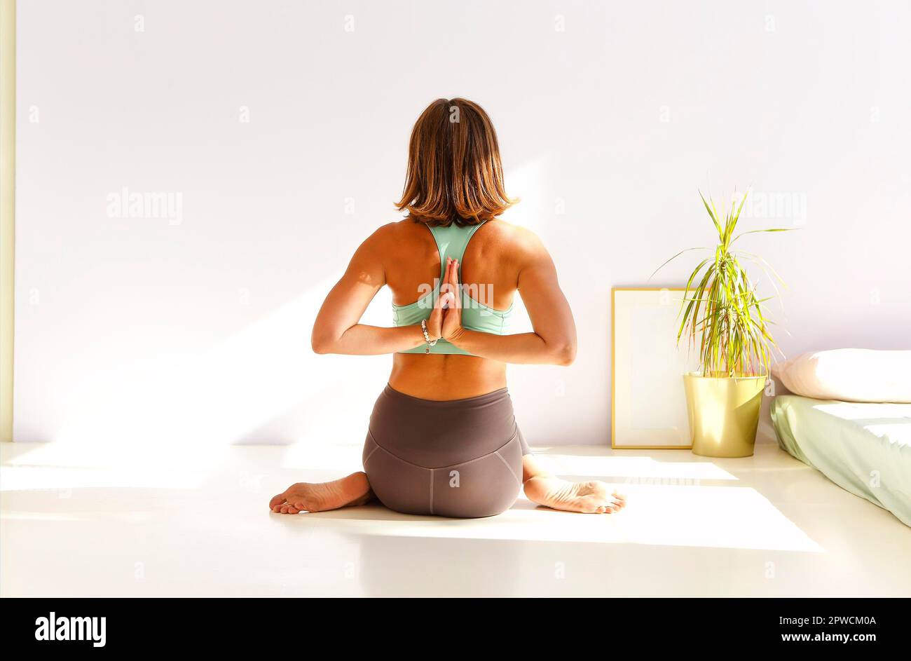 Vue latérale de la femme calme dans les vêtements de sport pratiquant le yoga Pompier pose tout en équilibrant les bras sur le tapis et en regardant loin Banque D'Images