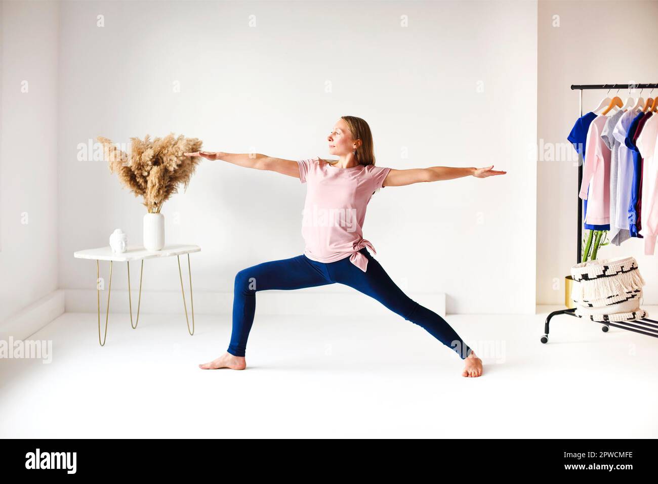 Calme femme dans les vêtements de sport pratiquant le yoga en posture tout en équilibrant et en regardant loin Banque D'Images