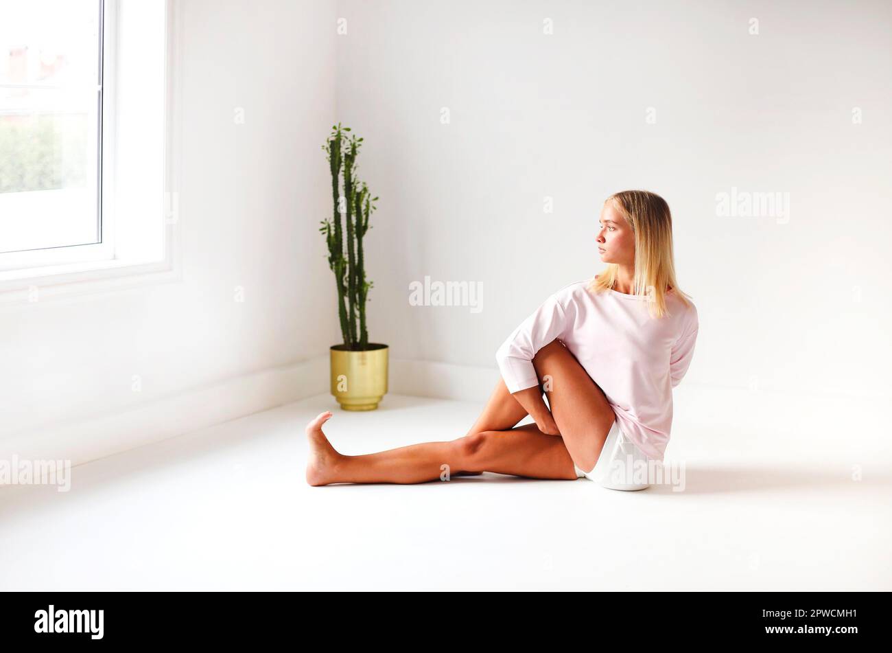 Calme femme dans les vêtements de sport pratiquant le yoga dans la posture de Firefly tout en équilibrant et en regardant loin Banque D'Images