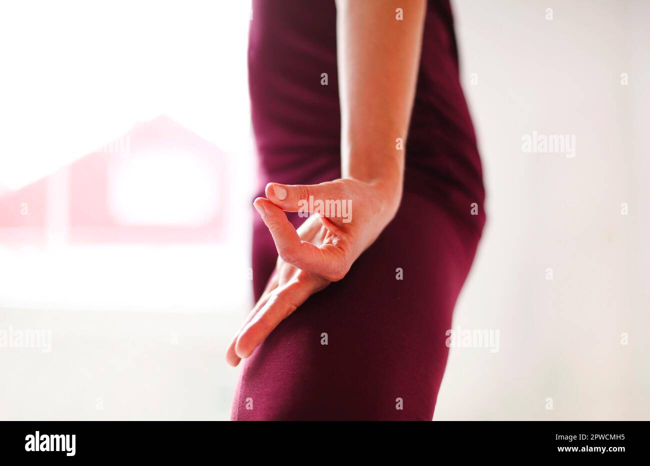Une vue rognée de la femme méconnue dans les vêtements de sport avec les mains de mudra sur le tapis et faisant du yoga tout en pratiquant la pleine conscience Banque D'Images