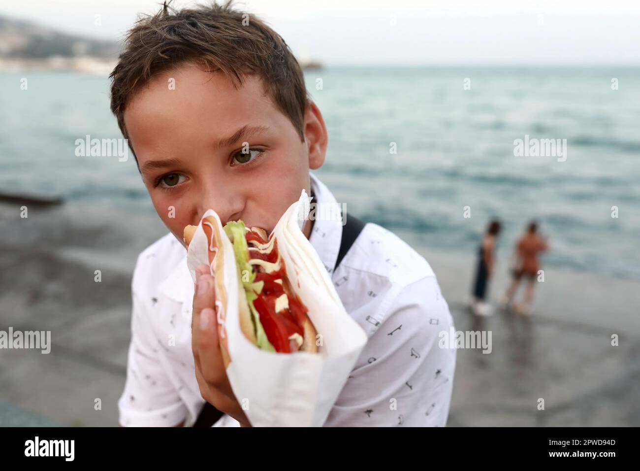 Enfant mangeant un hot dog sur le remblai de Yalta, Crimée Banque D'Images