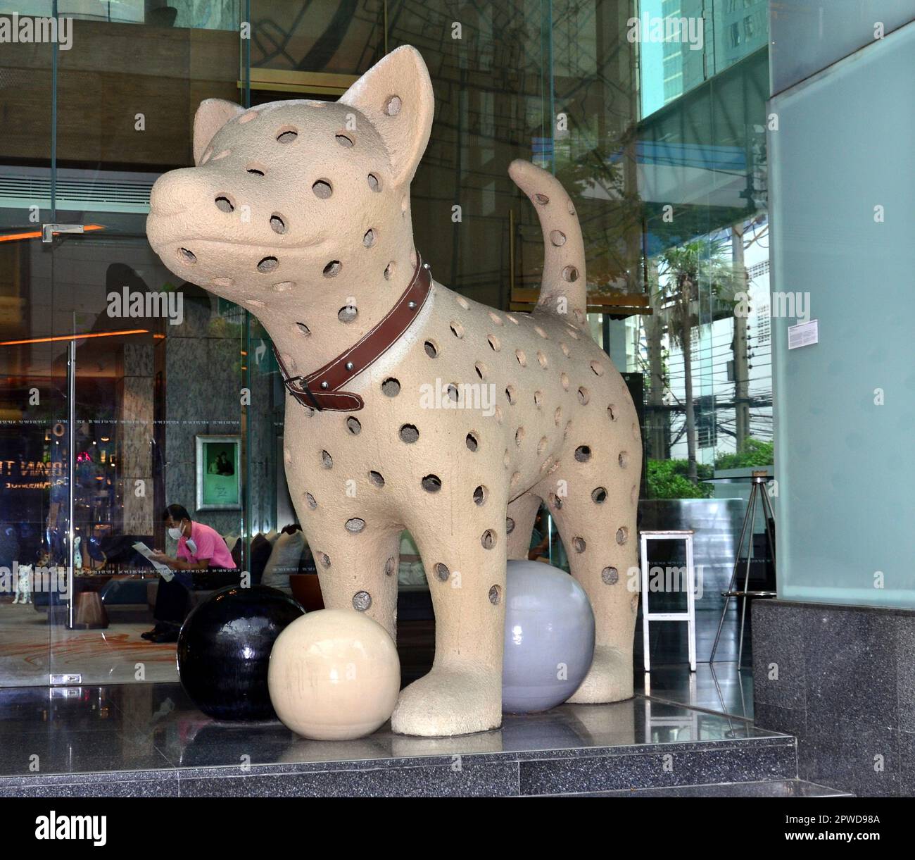 « I-Jud » ou « Dots Dog » est une grande sculpture emblématique d'un chien joueur à l'entrée principale de l'hôtel le Méridien, à Bangkok. Elle a été créée par Wasinburee Supanichvorapasarch, un artiste thaïlandais. Banque D'Images