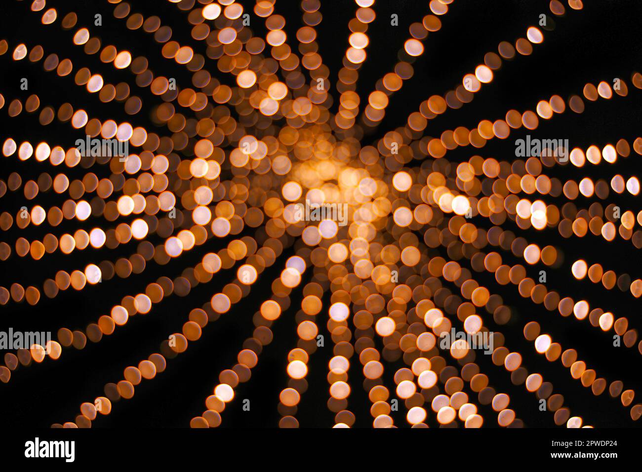 Boules de bokeh de Noël de couleur jaune et orange abstraite et boules de bokeh clair lumières non-focus texture sur fond noir Banque D'Images