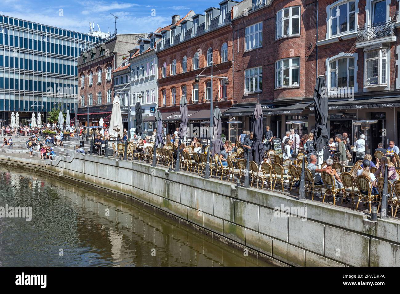 Les gens dans les bars, cafés et restaurants sur la rivière Aarhus terrasses riveraines dans le centre-ville par Aboulevarden, Aarhus Danemark. Banque D'Images