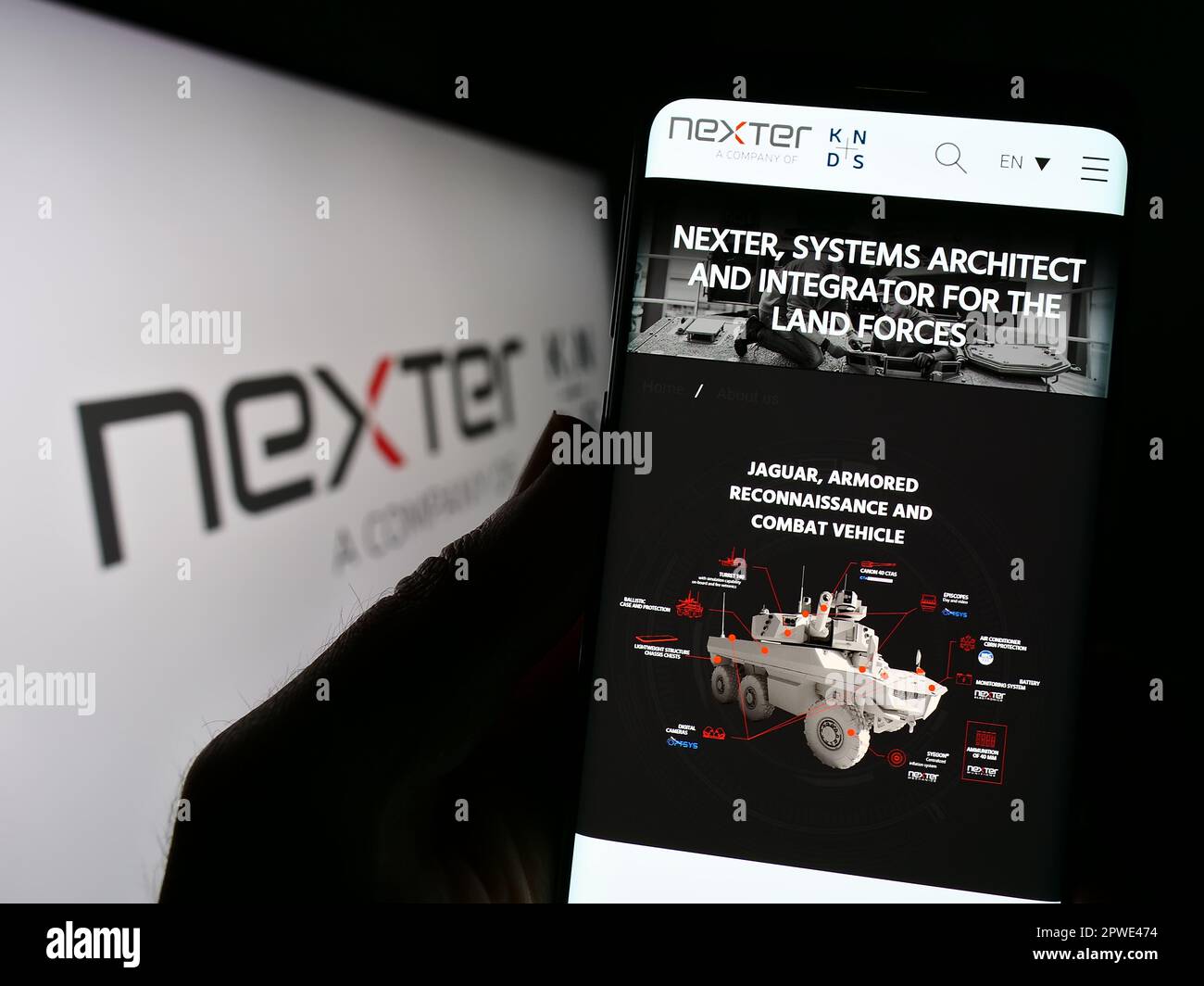 Personne tenant un téléphone portable avec la page web de la société de défense française Nexter sa à l'écran devant le logo. Concentrez-vous sur le centre de l'écran du téléphone. Banque D'Images