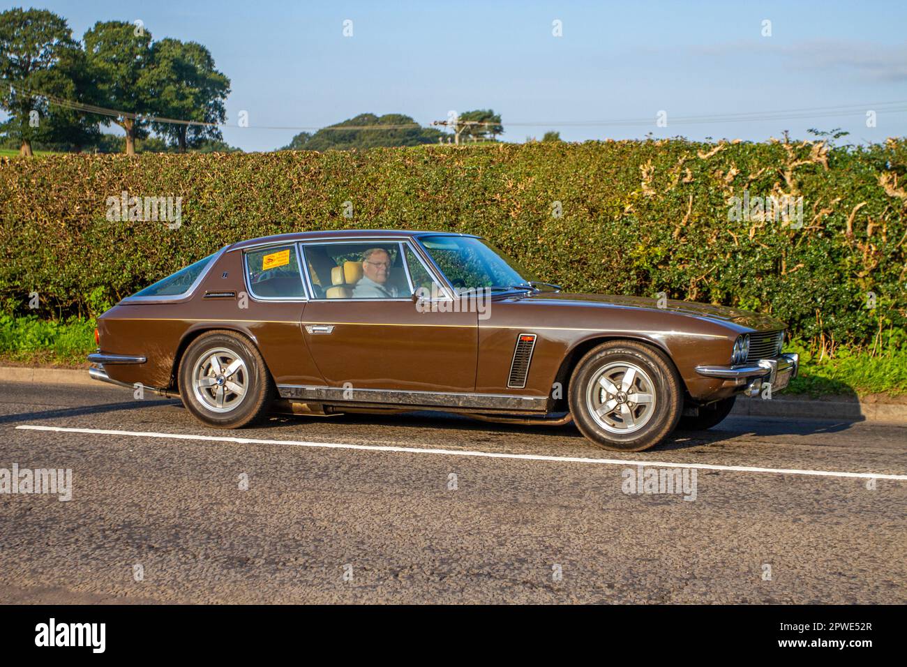 1973 70s 70 Jensen Interceptor Auto Brown Pétrol 7212 cc; voiture classique isolée voyageant sur une voie de campagne à Congleton, Royaume-Uni Banque D'Images