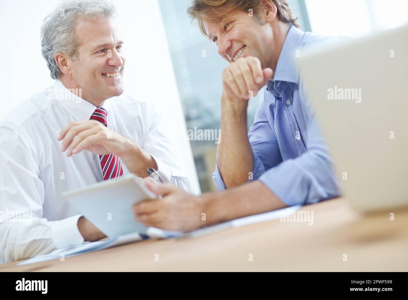 Brainstorming avec un résultat positif. Deux associés d'affaires masculins profitant d'une réunion au bureau. Banque D'Images