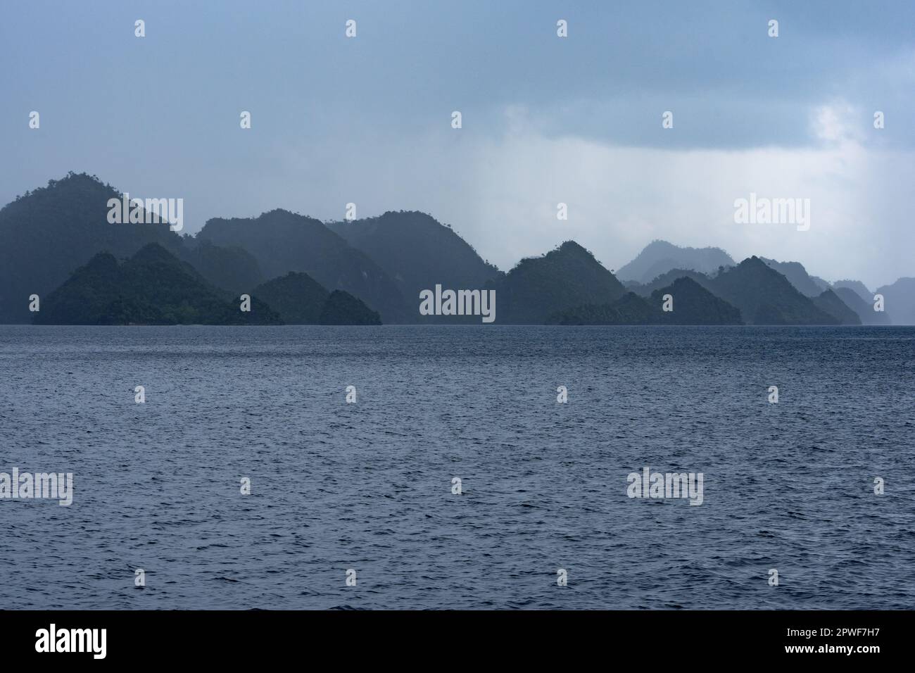 Un calmar de pluie dévie sur des îles de calcaire éloignées à Misool, Raja Ampat, Indonésie. Cette région tropicale est connue pour sa grande biodiversité. Banque D'Images