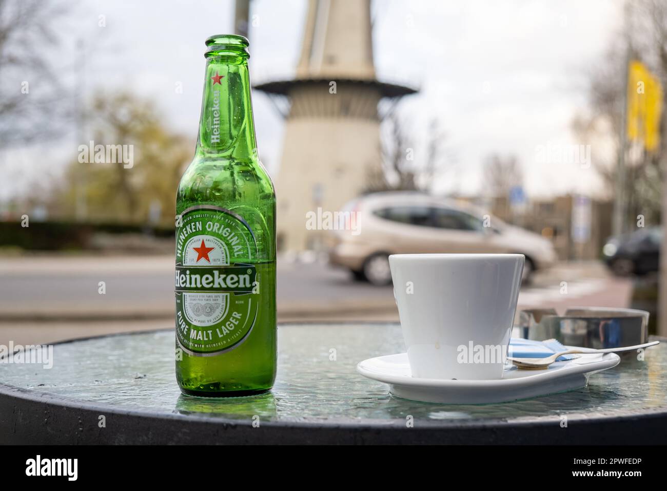 Rotterdam, pays-Bas - 25 mars 2023 : bière Heineken dans une bouteille et une tasse de café sur une table dans un café d'été. Banque D'Images