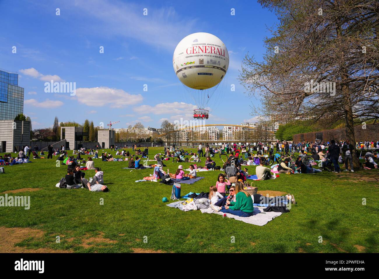 Paris, France - 9 avril 2023 : Parisiens pique-nique au printemps sur l'herbe du Parc André Citroën sur la rive gauche de Paris, sous un a chaud Banque D'Images