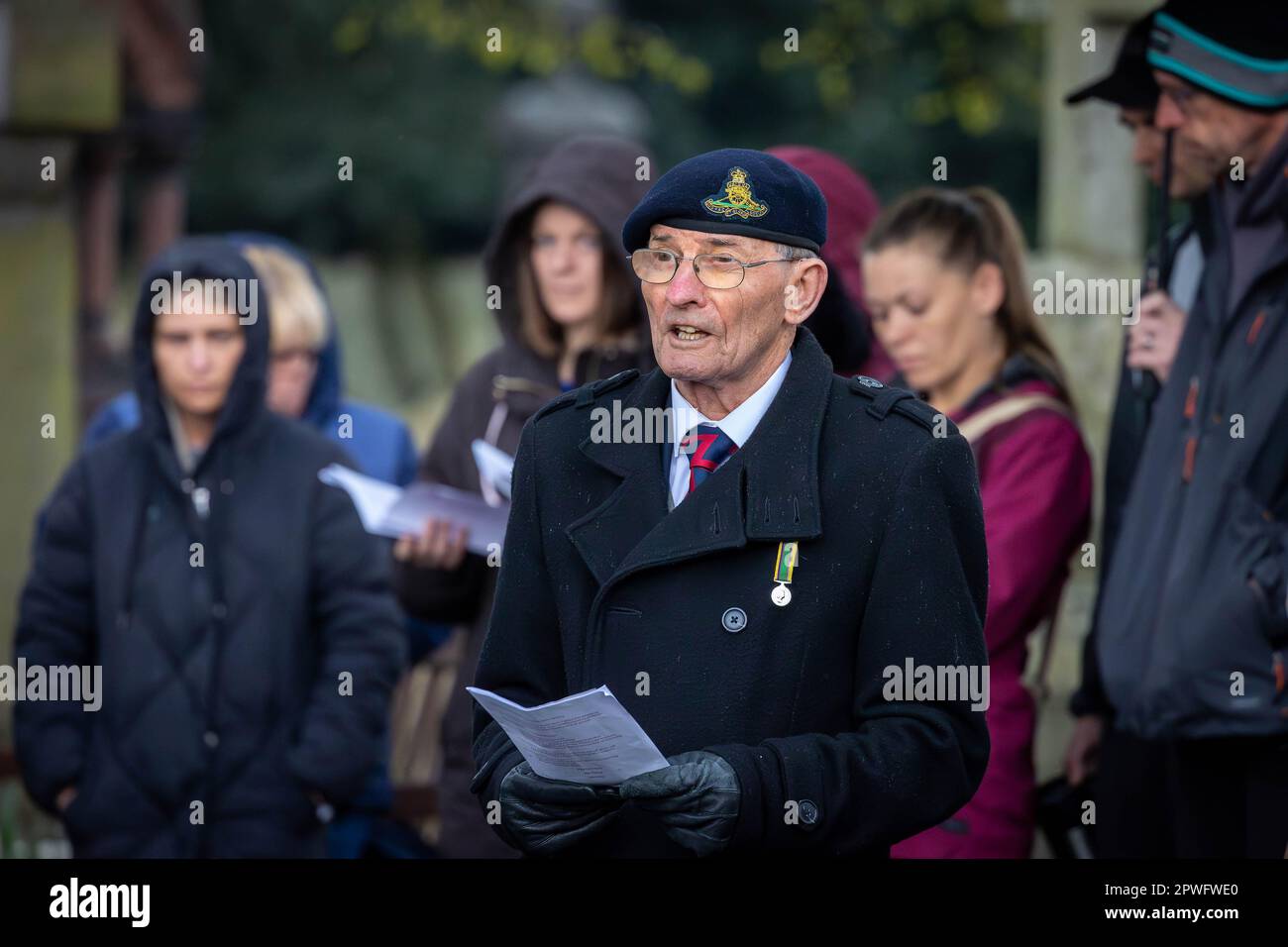 Un représentant de l'Association des vétérans régimentaires du duc de Lancaster lit un dévouement à la Journée de l'ANZAC à Soldier's Corner, Warrington, 2023 Banque D'Images