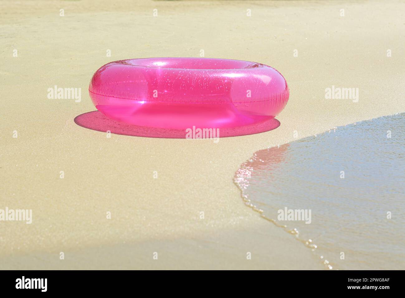 Anneau gonflable lumineux sur la plage de sable près de la mer Banque D'Images