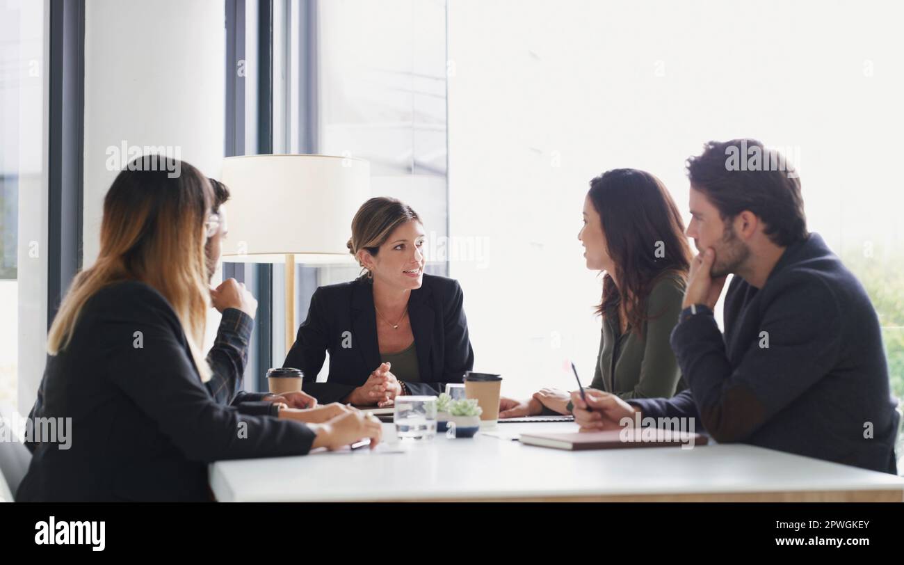 Nous avons un grand plan d'action à mettre en œuvre. un groupe d'hommes d'affaires ayant une réunion dans une salle de réunion. Banque D'Images