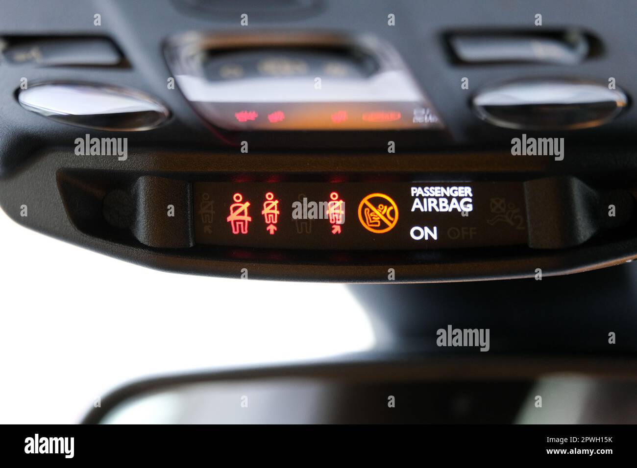 Le témoin de ceinture de sécurité et d'airbag passager s'allume sur le rétroviseur intérieur de la voiture, sous le phare. Signes à l'intérieur de la voiture. Mise au point sélective. Banque D'Images