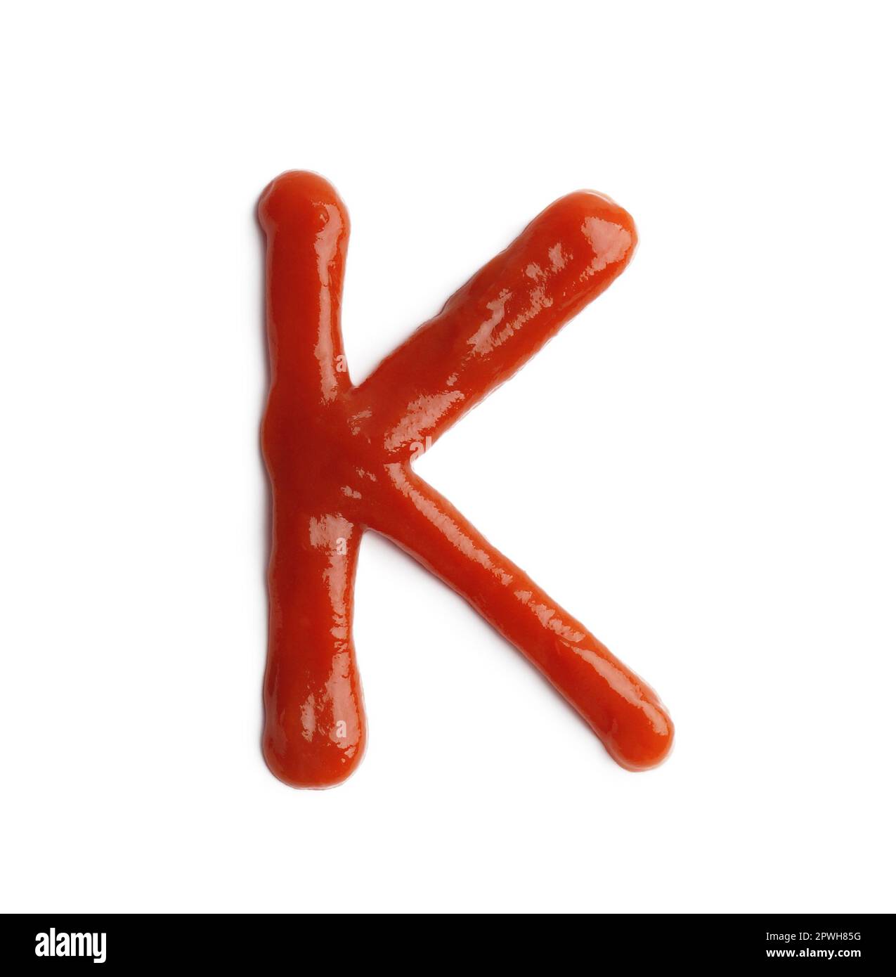 Lettre K écrite avec ketchup sur fond blanc Banque D'Images