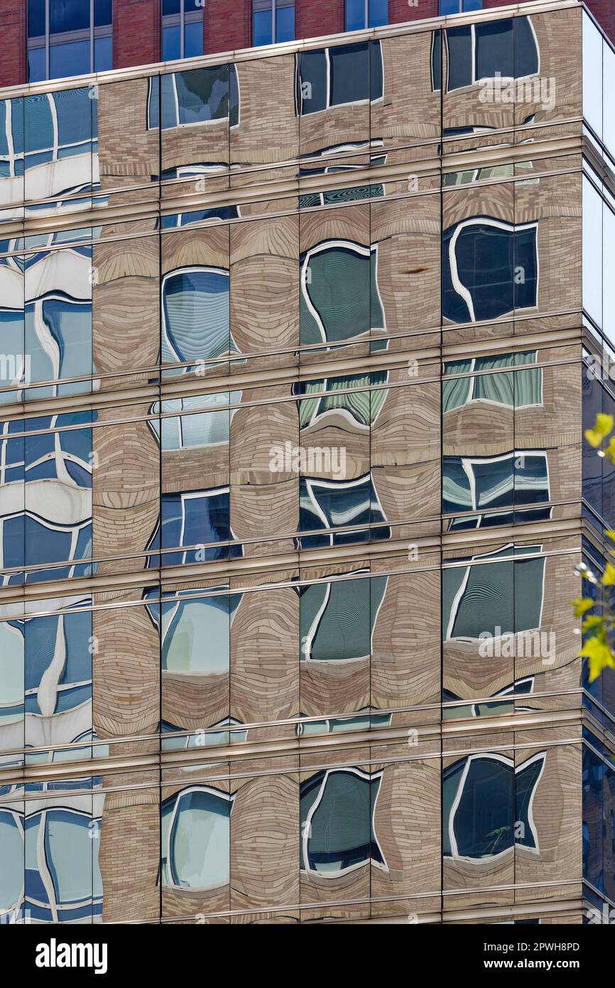 Le mur-rideau en verre miroir au sommet du 147 Columbus Avenue reflète des bâtiments à l'ouest de Columbus Avenue, sur Lincoln Square à Manhattan. Banque D'Images
