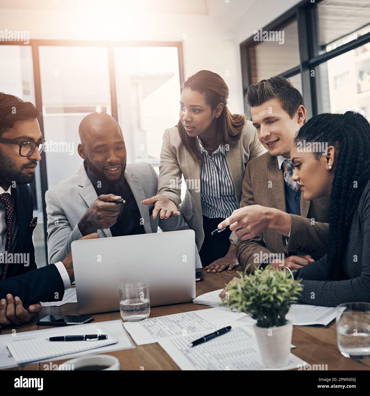 Faire en sorte que toute l'équipe se charge de cette tâche. un groupe de jeunes hommes d'affaires utilisant un ordinateur portable lors d'une réunion dans un bureau moderne Banque D'Images