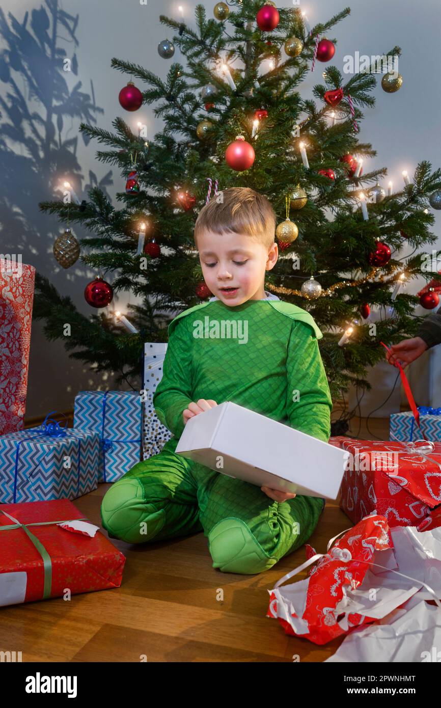 Jeune garçon ouvrant cadeau de Noël à la maison Banque D'Images
