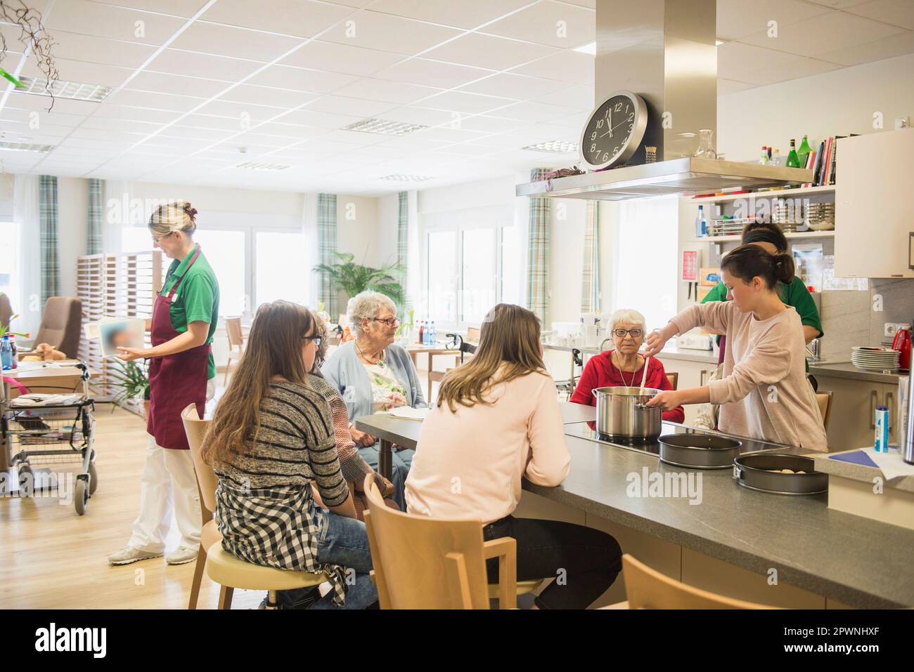 Infirmière avec des femmes et des filles âgées préparant de la nourriture à la maison de repos Banque D'Images