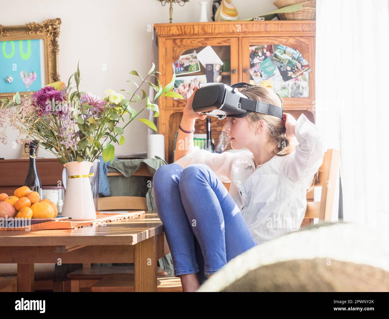 Fille portant des lunettes de réalité virtuelle dans le salon Banque D'Images