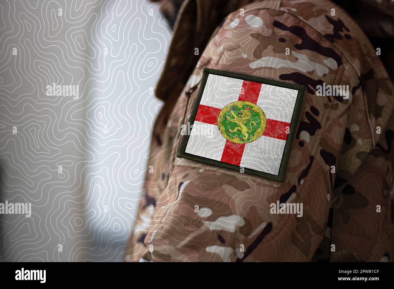 Soldat d'Alderney. Soldat avec drapeau Alderney, drapeau Alderney sur un uniforme militaire. Vêtements de camouflage Banque D'Images