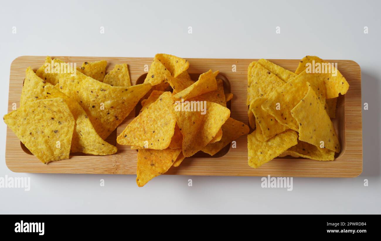 Doritos est une marque américaine de croustilles aromatisées. Grains de maïs doritos épicés sur un panneau de bois. Banque D'Images