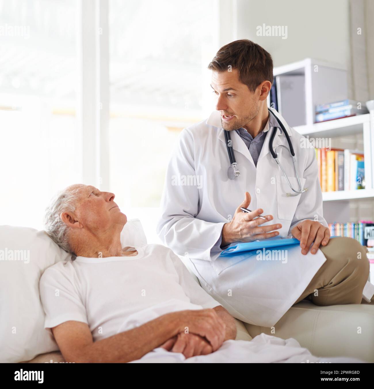 Explication simple. un beau médecin masculin expliquant quelque chose à un patient âgé. Banque D'Images