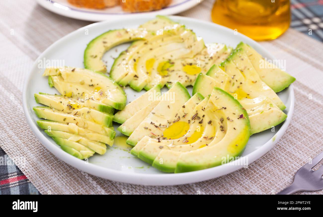 pulpe d'avocat mûre coupée en morceaux saupoudrée de jus de citron sur une assiette Banque D'Images