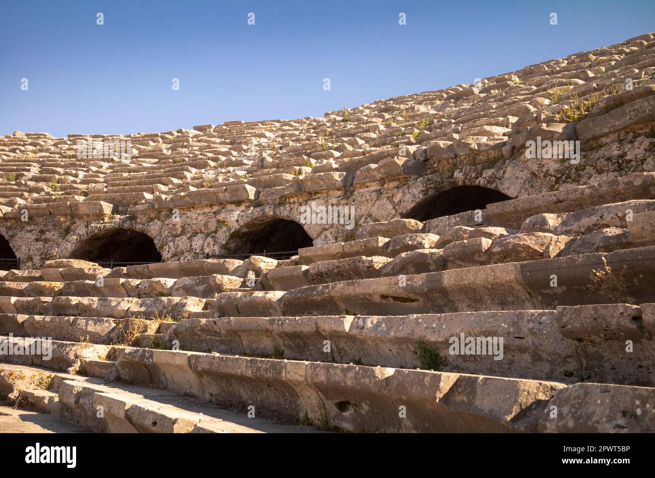 En regardant des marches escarpées devant des rangées de bancs de pierre, vous pourrez vous asseoir à l'amphithéâtre de l'ancienne ville romaine de Side dans la province d'Antalya, en Turquie (Turkiye). T Banque D'Images