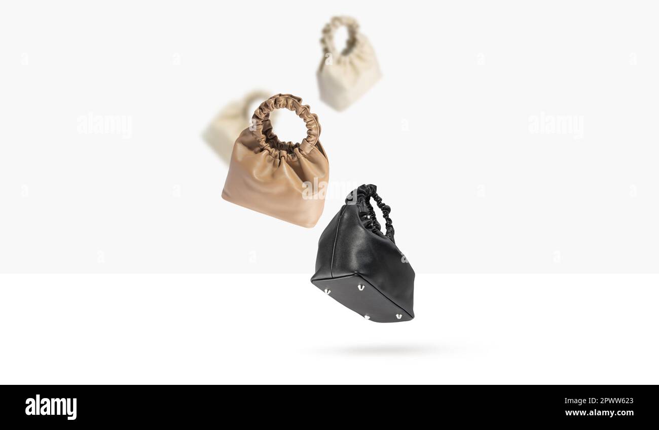 Ensemble de sacs à main en cuir ECO de différentes couleurs et de côtés volant sur un fond gris. Accessoires féminins tendance. Design minimaliste avec sac. Banque D'Images
