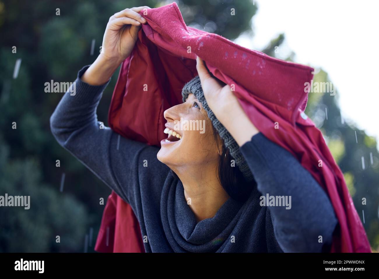 J'ai oublié mon parapluie. une femme tenant son manteau sur sa tête pendant  qu'elle est dehors sous la pluie Photo Stock - Alamy