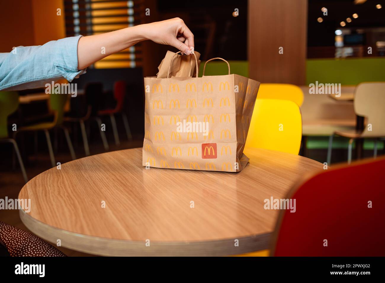 Valence, Espagne - 16 octobre 2022: Emballage de sac de papier conception pour le service de livraison appartenant à la restauration rapide restaurant McDonalds sur une table à la ville café Banque D'Images