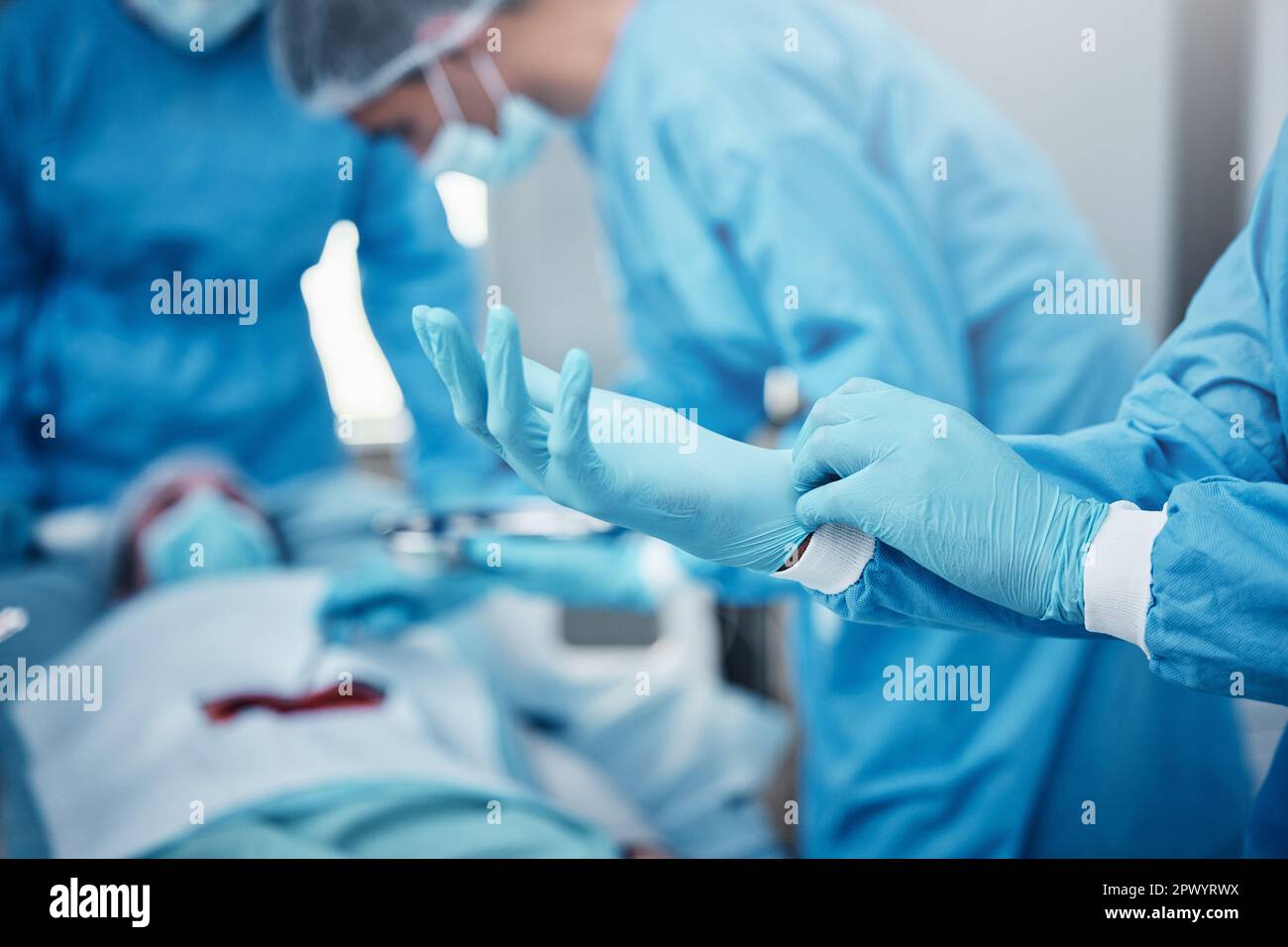 Hôpital, chirurgie et médecins en équipe avec des gants, epi et sécurité pour aider le patient au lit avec le cancer de l'estomac. Groupe de travail d'équipe de médecins, opération médicale Banque D'Images