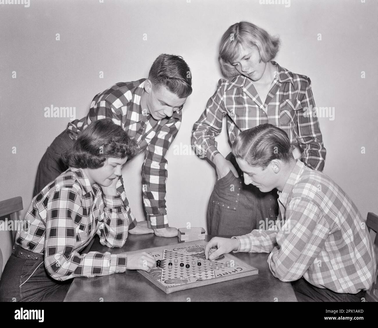 1950S QUATRE ADOLESCENTS DEUX GARÇONS DEUX FILLES PORTANT TOUS DES CHEMISES EN FLANELLE À CARREAUX JOUANT À REGARDER UN MATCH DES DAMES CHINOISES ENSEMBLE - J3765 LAN001 HARS FRÈRE VIEILLE MODE SŒUR 1 JEUNE STYLE DE COMMUNICATION AMI TRAVAIL D'ÉQUIPE CONCURRENCE JOIE STYLE DE VIE FEMMES FRÈRES MAISON RURALE VIE COPIE ESPACE AMITIÉ DEMI-LONGUEUR PERSONNES MÂLES ADOLESCENT FILLE ADOLESCENT GARÇON PLAID FRÈRES ET SŒURS DAMES B&W DATING BUTS BONHEUR BILLES HAUT ANGLE LOISIRS STRATÉGIE LOISIRS CHEMISES ATTRACTION FRÈRE CONNEXION TRIBUNAL FLANNEL AMICAL ÉLÉGANT ADOLESCENTS POSSIBILITÉ COOPÉRATION JEUNES ACTIVITÉ SOCIALE TOGETHERNESS Banque D'Images