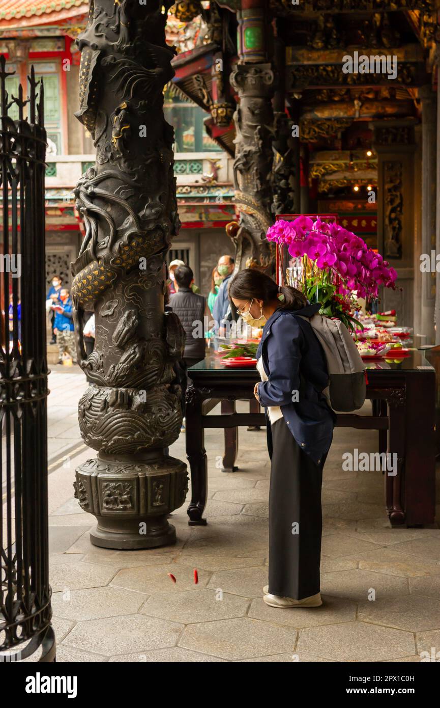 Fille jetant des blocs de lune au temple de Longshan, Taiwan, Taipei Banque D'Images