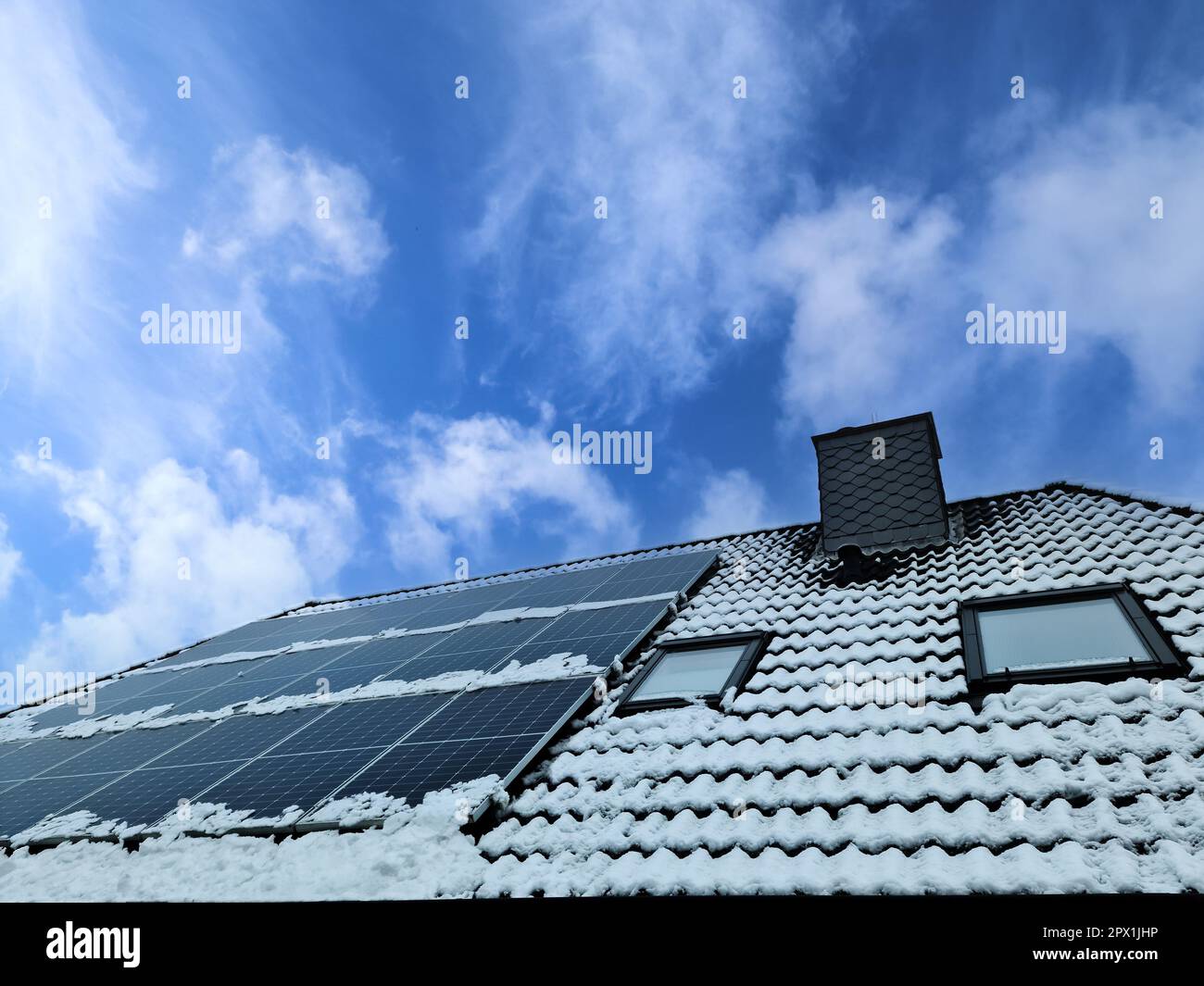 Panneaux solaires produisant de l'énergie propre sur un toit à neige à covered d'une maison résidentielle Banque D'Images