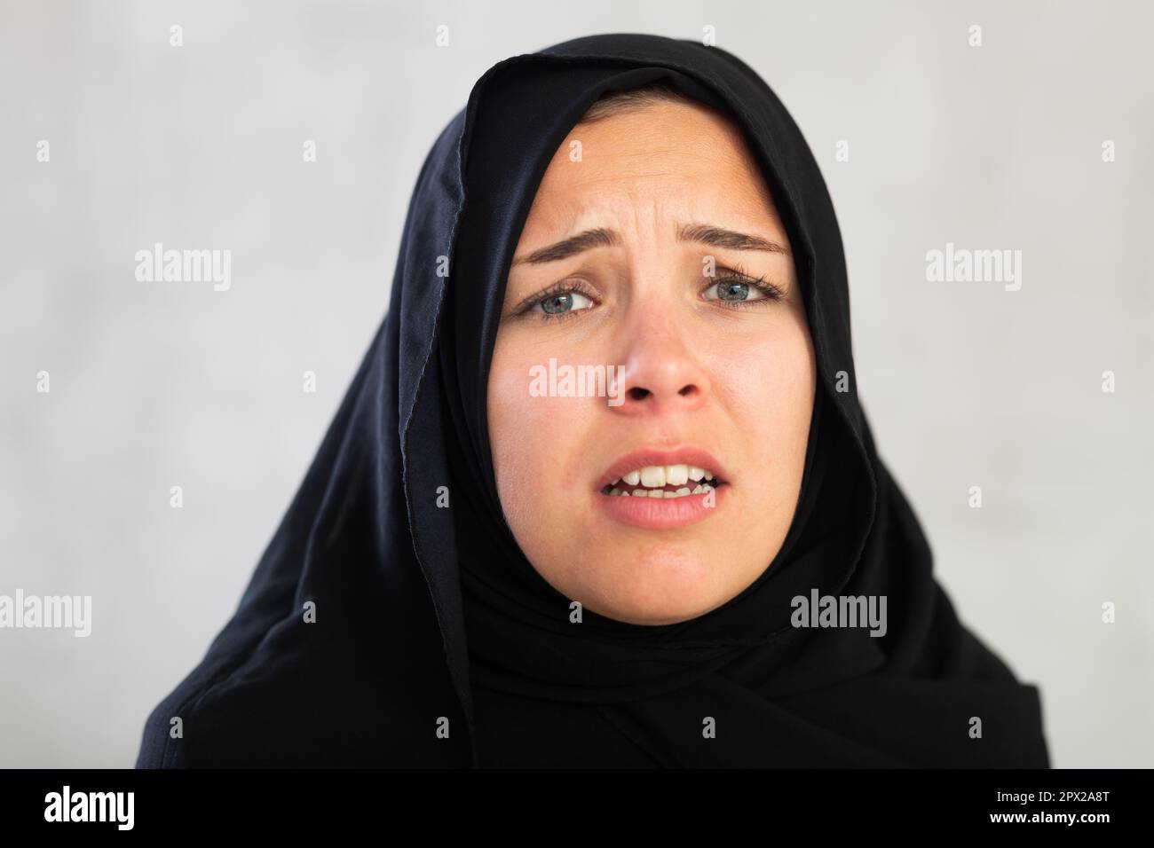 Une jeune femme inquiète vêtue de vêtements islamiques traditionnels Banque D'Images