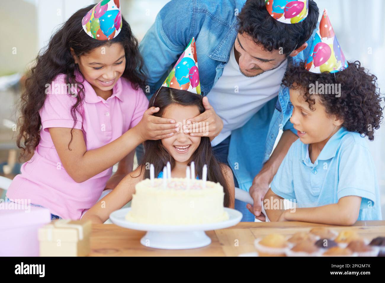 Shes obtenir une surprise d'anniversaire. une fille couvrant les yeux de ses amis à sa fête d'anniversaire. Banque D'Images