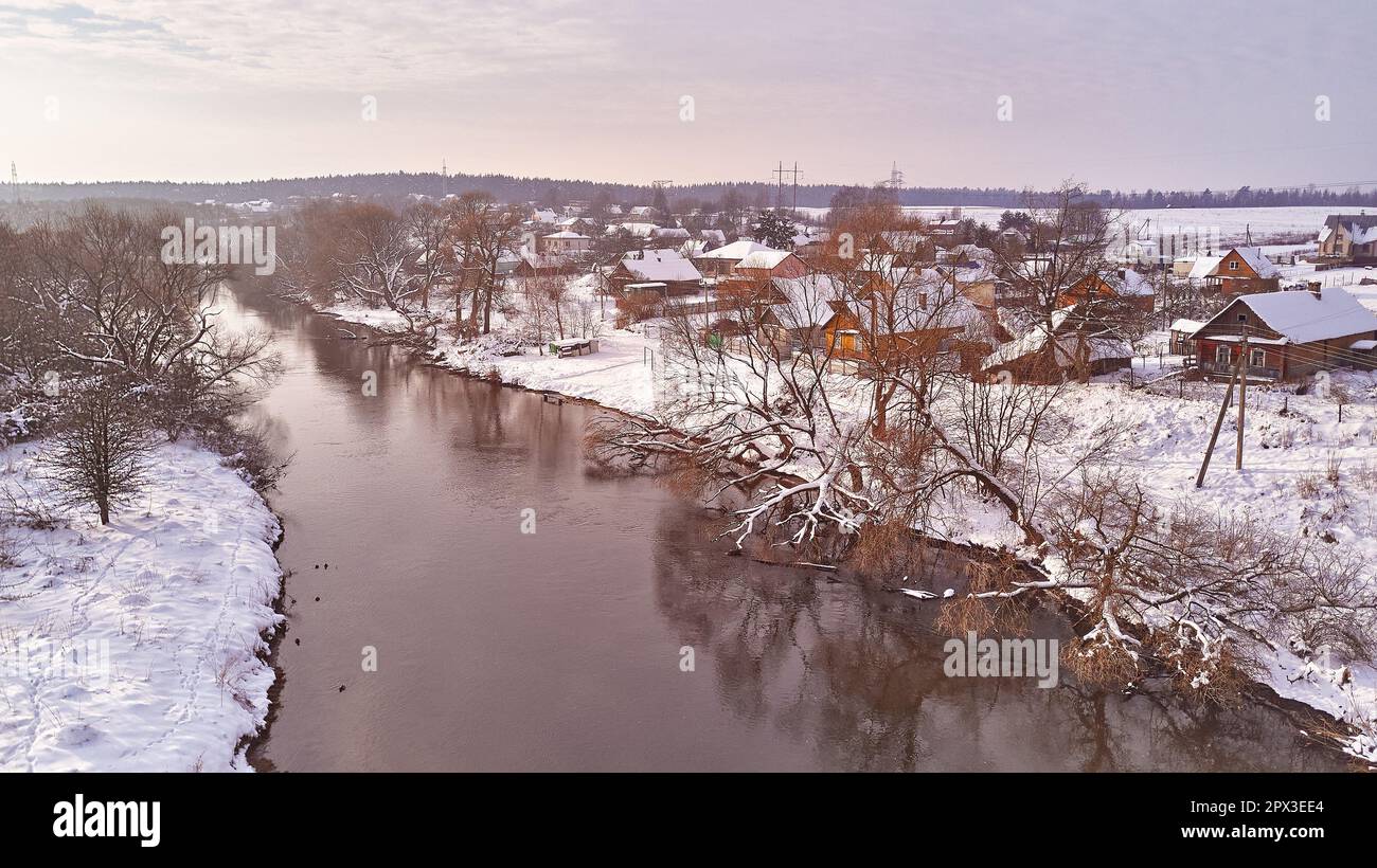 Paysage de rivière en hiver, champs enneigés. Le givre sur les arbres, les plantes. Soirée givrée. Temps ensoleillé nuageux et brumeux. Saison froide. Ambiance nature calme. V Banque D'Images