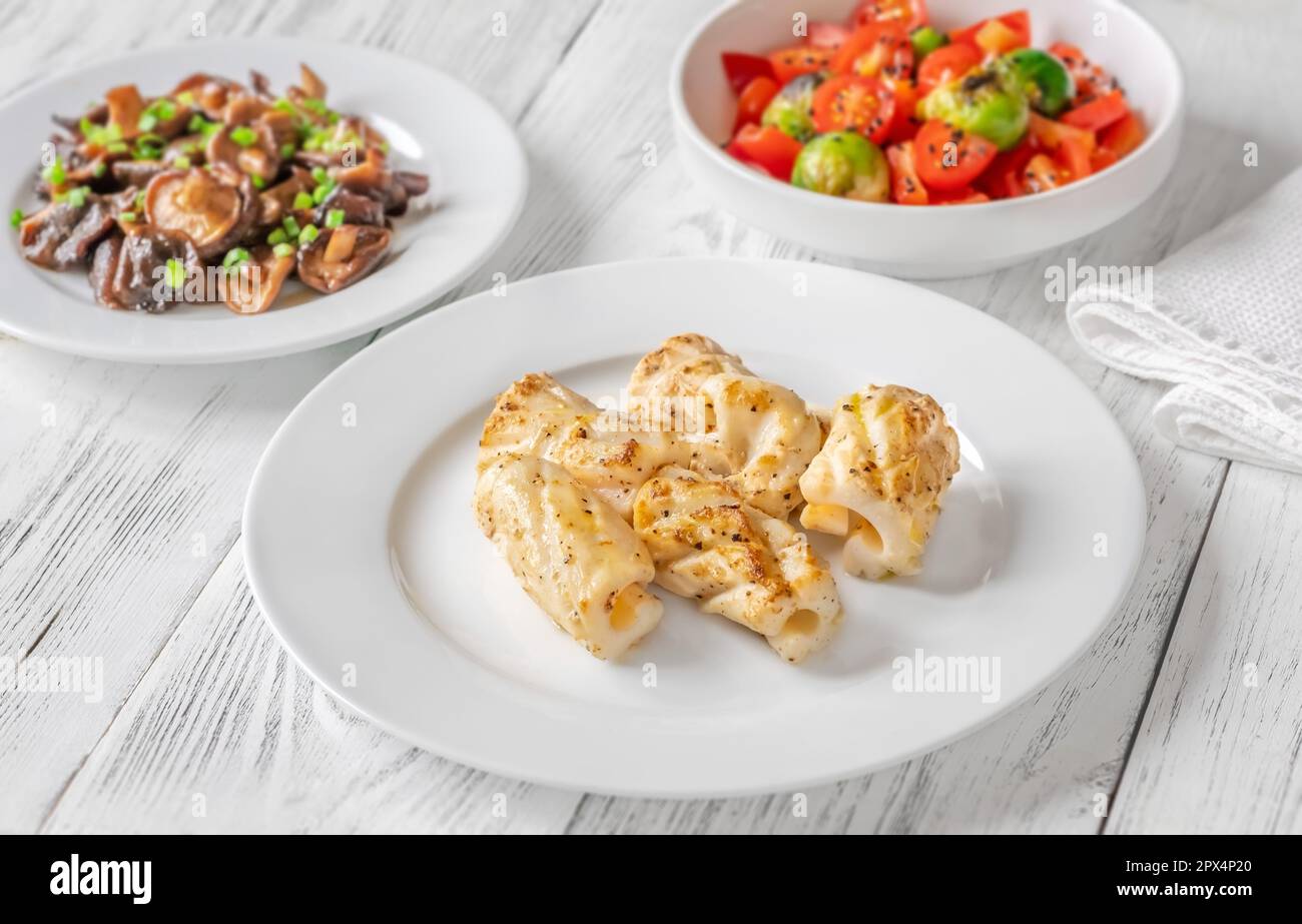 Portion de calamars frits avec champignons shiitake et salade de tomates Banque D'Images
