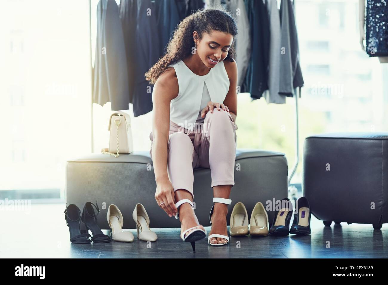 Je veux les emmener tous à la maison. une jeune femme attirante essayant  des chaussures tout en faisant du shopping dans une boutique Photo Stock -  Alamy