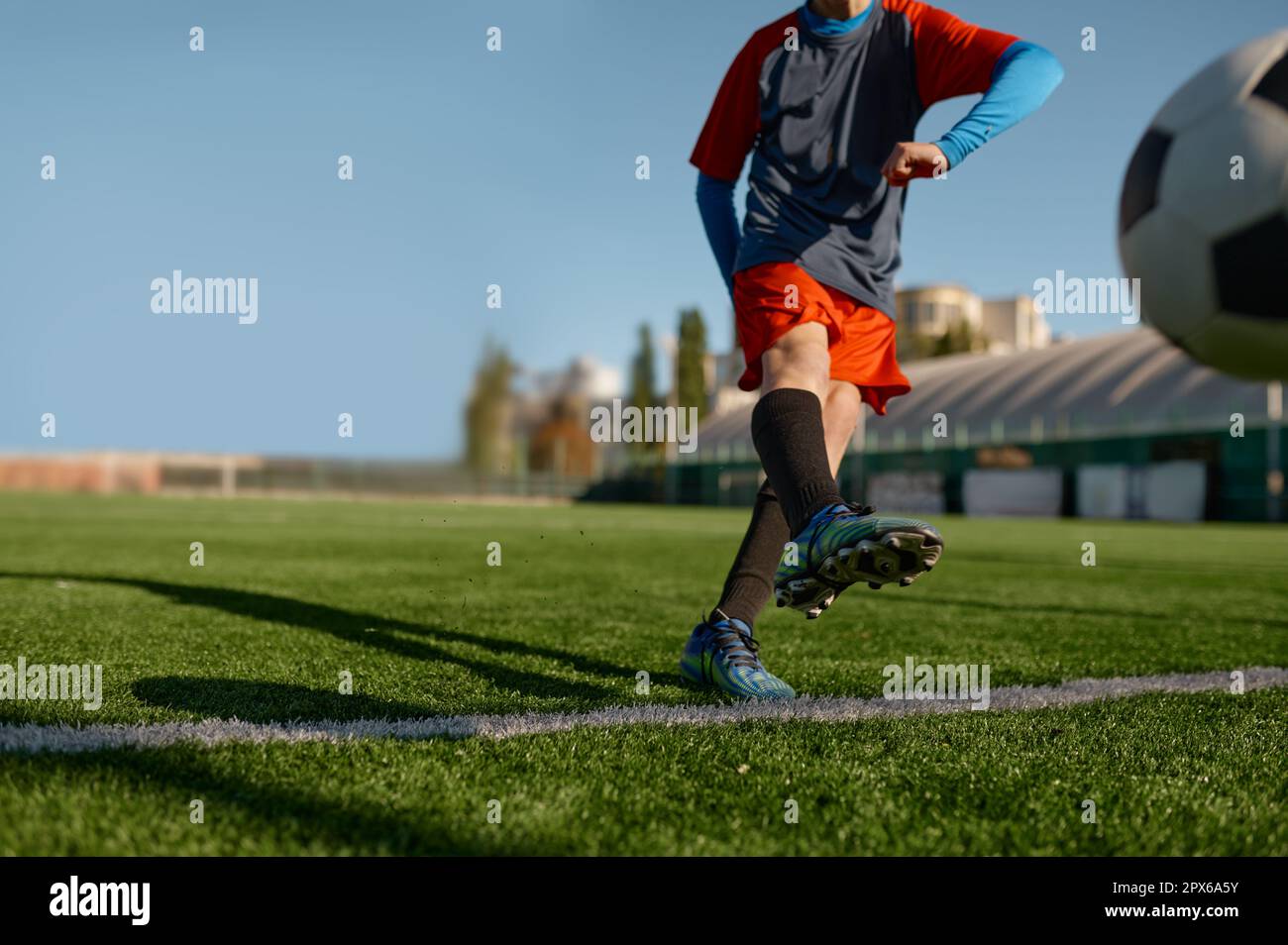 Jeune gardien de but de football commençant le jeu kicking ball à partir de la ligne de but blanche. Tournoi de football ou entraînement pour enfants concept Banque D'Images