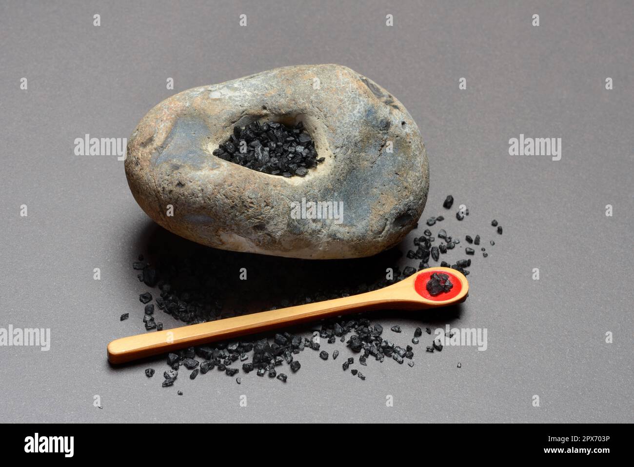 Sel hawaïen noir sur les cuillères et dans la pierre creuse, sel de mer avec charbon actif Banque D'Images