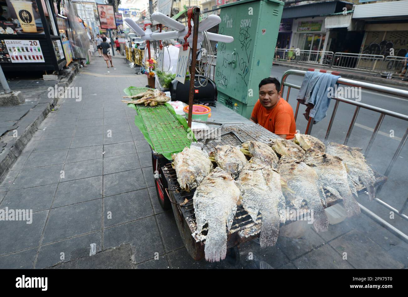 Un vendeur de Tilapia en croûte de sel sur la route Charoen Krung à Bangkok, en Thaïlande. Banque D'Images
