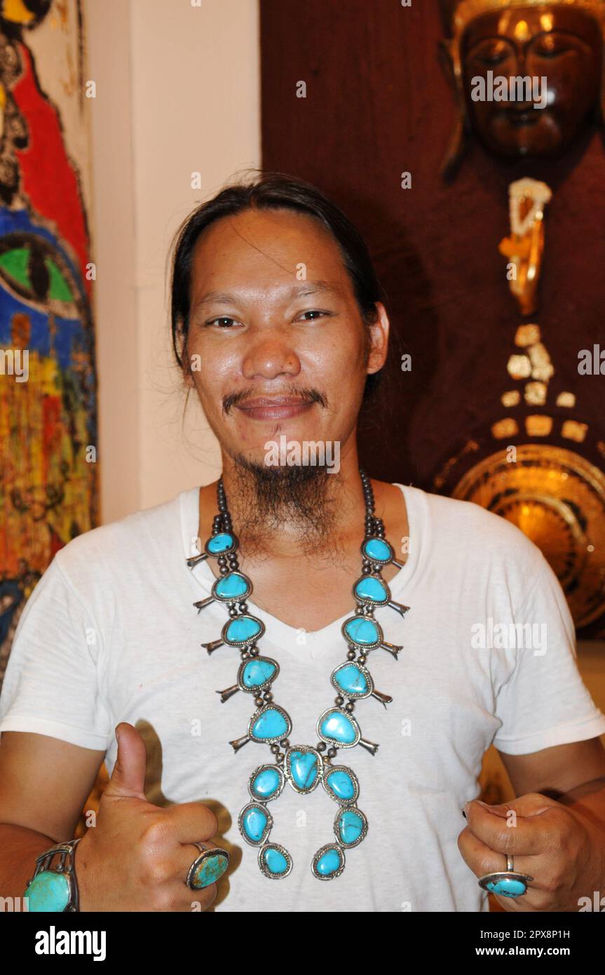 Un homme thaïlandais élégant portant un collier turquoise et argenté en forme de fleur de squash. Photo prise au marché du week-end de Chatuchak à Bangkok, Thaïlande. Banque D'Images