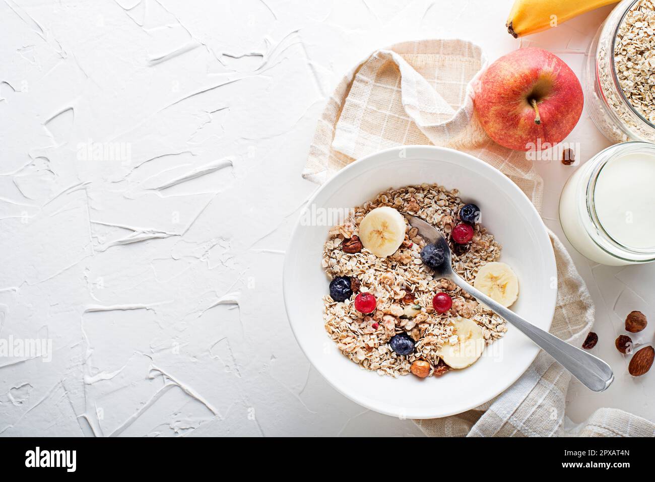 Un bol de granola et de muesli secs servi avec des fruits frais et des noix. Plaque à flocons d'avoine. Alimentation saine, alimentation. Vue de dessus. Banque D'Images